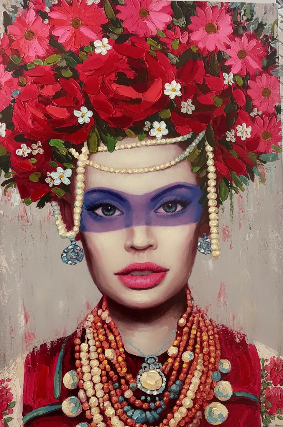 Portrait of a woman wearing a crown of red flowers and strands of pearls